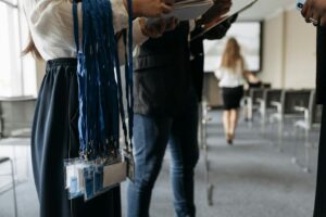 Des personnes dans une salle de conférence se préparent avec des cordons et des badges.