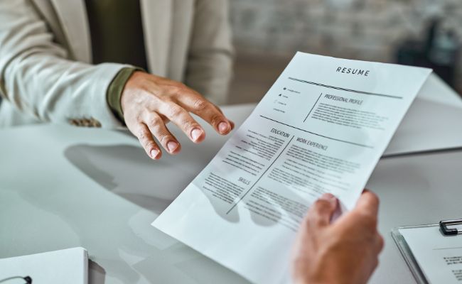Deux personnes échangent un CV intelligent lors d'un entretien.